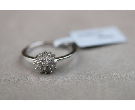 A diamond 9ct white gold three tier cluster ring, nineteen small round brilliant cut diamonds, bead settings, diameter of hea