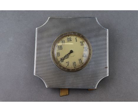An Art Deco silver 8 day travel timepiece, stylised octagonal form with engine turned decoration, champagne dial with enamell