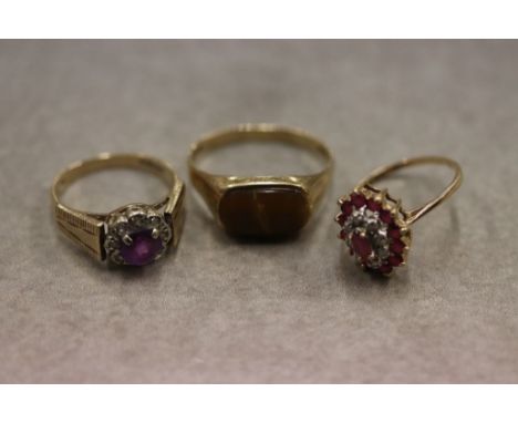 Three 9ct yellow gold dress rings to include a ruby and diamond 9ct yellow and white gold set three tier oval cluster ring, t