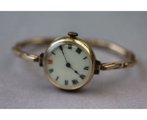 A circa 1920s/ 1930s 18ct yellow gold cased wristwatch, cream enamel dial with red and black Roman numerals, black poker hand