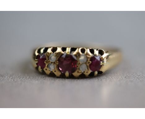 An early 20th century ruby and diamond 18ct yellow gold boat head ring, three graduated round mixed cut rubies with rose cut 