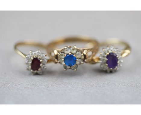 Three gem set 9ct yellow gold cluster rings, comprising a ruby and diamond cluster ring, an amethyst and white stone cluster 