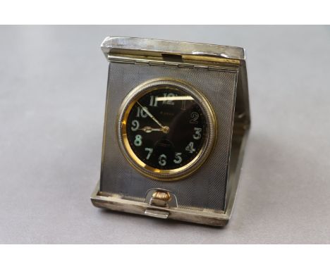 Art Deco Goldsmiths & Silversmiths silver rectangular cased 8 day travel clock, the clock bearing black enamel dial, luminous