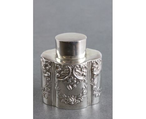 A late Victorian silver tea caddy of serpentine form, repoussé floral and foliate decoration to body, gilt interior, makers m