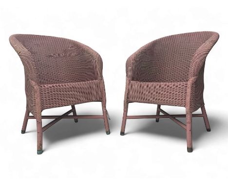Pair of Lloyd Loom design tub chairs, each with woven wicker construction, curved backrests and painted in a soft pink finish