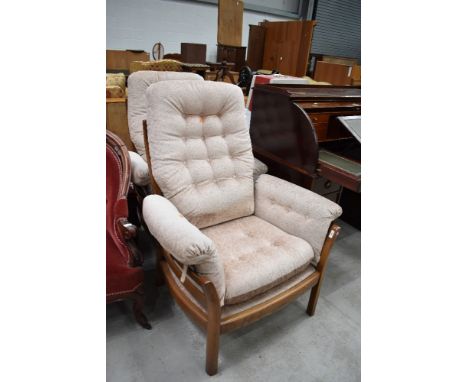 Two modern Ercol wing back arm chairs in a medium stain