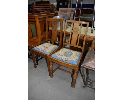 Two early to mid 20th Century oak framed dining chairs having matching drop in tapestry seats