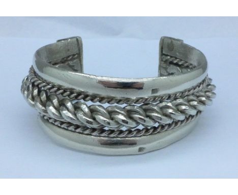 A white metal bangle with continental control marks