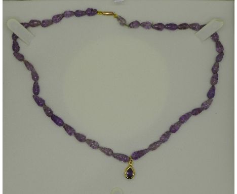 A carved amethyst necklace with a 9ct gold fastener