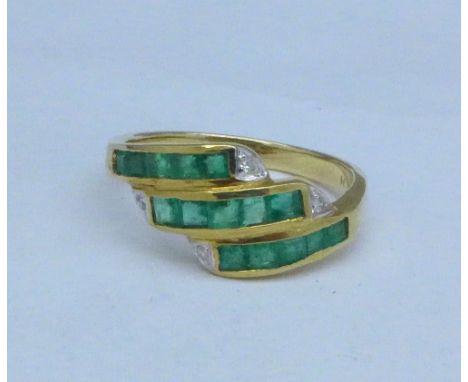 An 18k gold ring, with channel set emeralds and diamonds, 4.4g, R