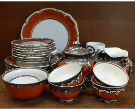 A twenty-seven piece porcelain tea service with applied silver decoration comprising a cake plate, six side plates and cups, 