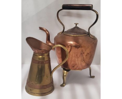 A VINTAGE COPPER KETTLE ON BRASS TRIPOD STAND AND FURTHER COPPER AND BRASS JUG 