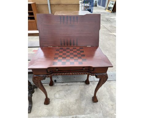 A VICTORIAN STYLE MAHOGANY FOLD OVER GAMES TABLE WITH CHESS AND BACKGAMMON DESIGN AND LOWER SLIDE DRAWER ON BALL AND CLAW FEE