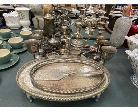 A LARGE QUANTITY OF VINTAGE SILVER PLATED ITEMS TO INCLUDE GALLERIED TRAYS, GOBLETS, CANDLEABRAS, A TANKARD, JUGS, ETC 