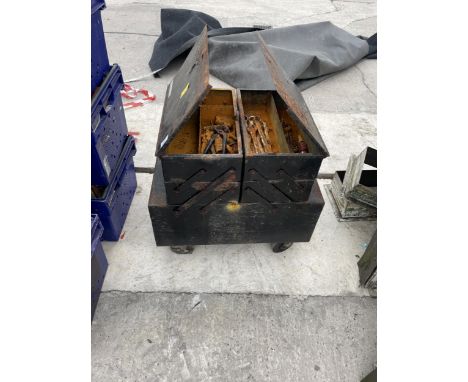 A SMALL FOUR WHEELED TOOL CHEST WITH AN ASSORTMENT OF HAND TOOLS 