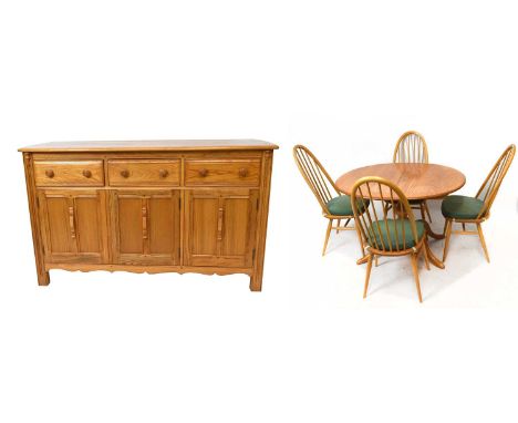 ERCOL; a light elm dining suite comprising drop-leaf table on swept supports, four spindle back dining chairs and side board 