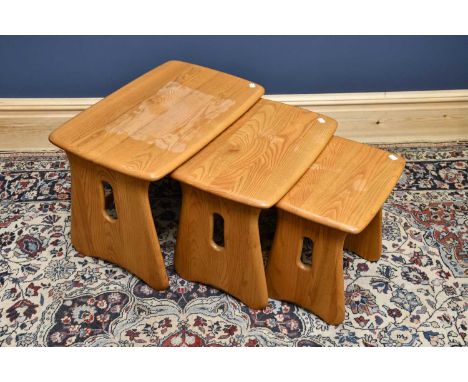 A nest of three Ercol style rectangular occasional tables, on standard end supports, height 45cm, width 63cm.