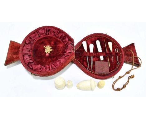 An Edwardian red velvet travelling sewing case, hinged cover enclosing button hook, pocket knife, mother of pearl handles, to