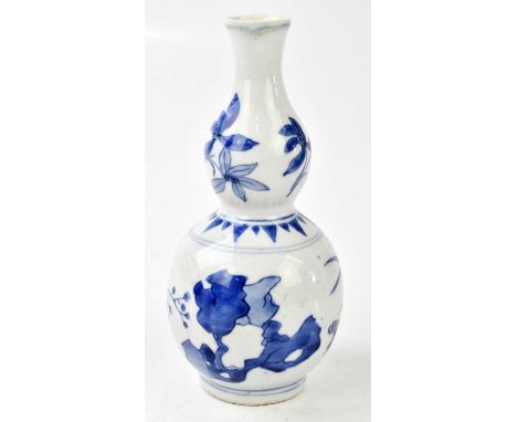 A Chinese blue and white double gourd vase, decorated with flowers and rockwork, height 20cm. Condition Report: Some light gr