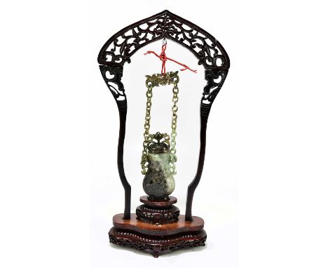 A contemporary polished jade hanging vessel and cover in fitted box and hanging from a pierced wooden stand, the vessel itsel