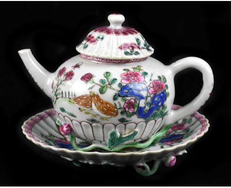 An 18th century Chinese Famille Rose teapot and stand painted in enamels with floral decoration, with applied floral motifs (