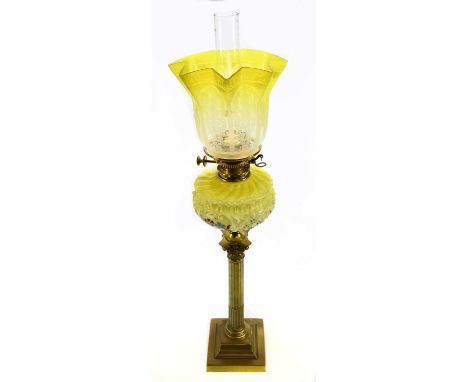 A Victorian brass oil lamp, the vaseline and clear coloured shade with etched decoration above the yellow glass reservoir wit