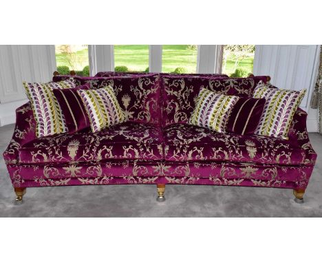 DURESTA; a triple drop arm sofa covered with a purple velvet style material with classical ferns and vase pattern, raised on 