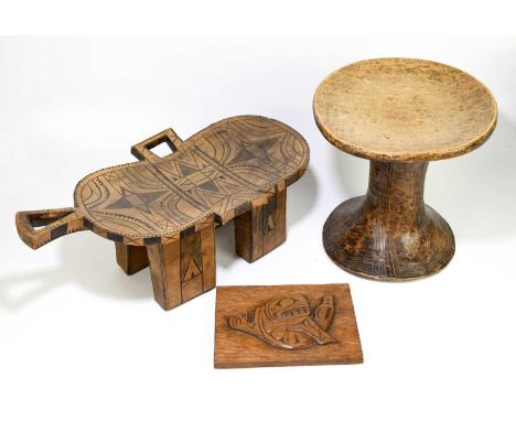TRIBAL ART; a carved soft wood circular stool with carved detailing, height 34cm, diameter 34cm, with a tribal four legged st
