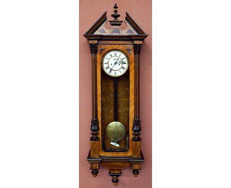 A 19th century walnut and stained pine Vienna wall clock with turned pediment above the circular enamelled dial set with Roma