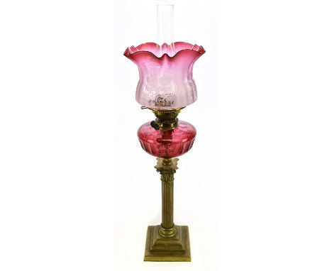 A Victorian brass oil lamp, with frosted cranberry glass shade, etched with floral detail above the cut glass cranberry glass