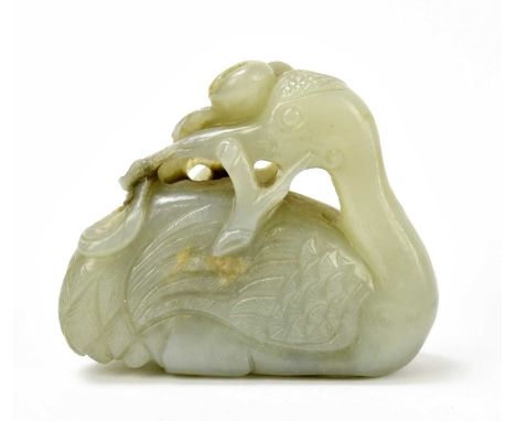 A 19th century small Chinese jade carving of a seated crane, his head turned over his back, and further carved with fruit and