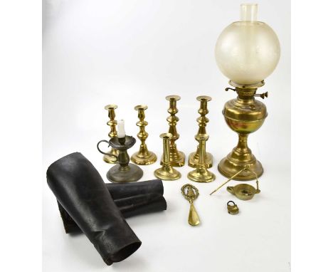 A brass oil lamp with frosted glass shade, together with a selection of candlesticks, two leather gaters, etc.
