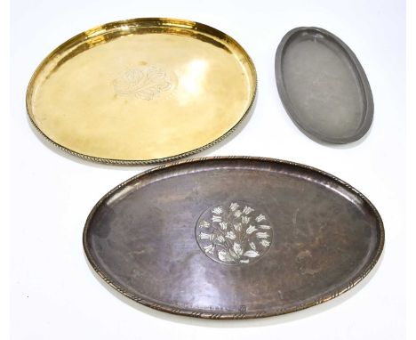 HUGH WALLIS; three Arts and Crafts trays comprising a circular brass example, diameter 46cm, an oval copper example, length 4