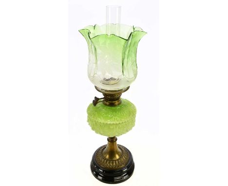 An early 20th century oil lamp with green and clear shade, with frosted floral decoration on a panelled ground, with moulded 