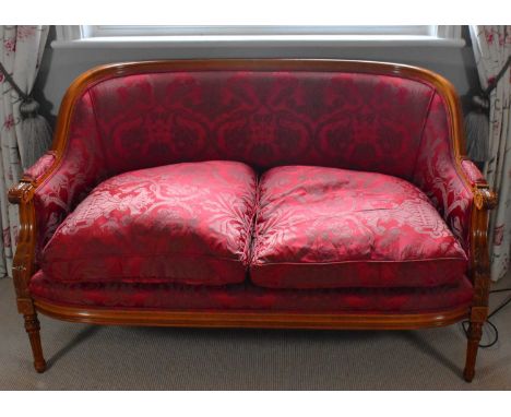 A reproduction walnut framed red upholstered two seater sofa.