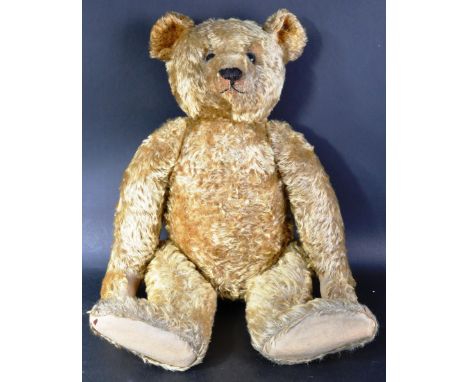 A large original circa 1930's German Steiff made soft toy teddy bear. The firmly stuffed bear having golden brown mohair, bla