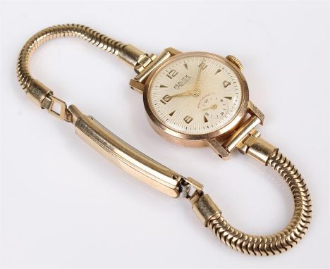 9 carat gold  Majex ladies wristwatch, champagne dial with gilt Arabic and arrow hour markers, subsidiary second dial, 20 mm 