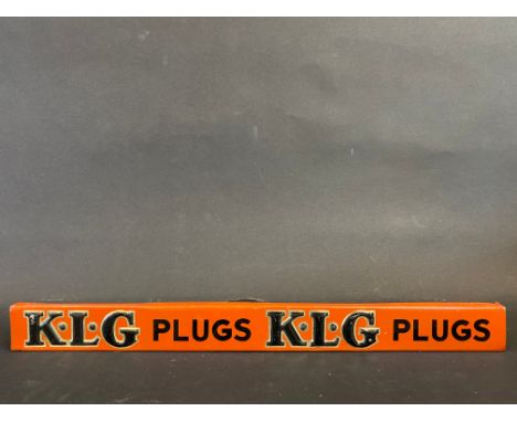 A K.L.G. Plugs embossed tin shelf strip, in good condition. 