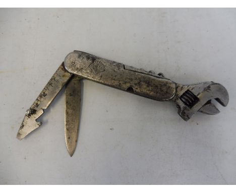 An unusual early Shell petrol motor oil company accessory multi tool which includes an adjustable spanner, corkscrew and penk
