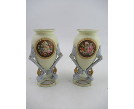 A pair of Grainger Worcester vases decorated with urns with reserved panels of flowers supported by a triform base, height 6.