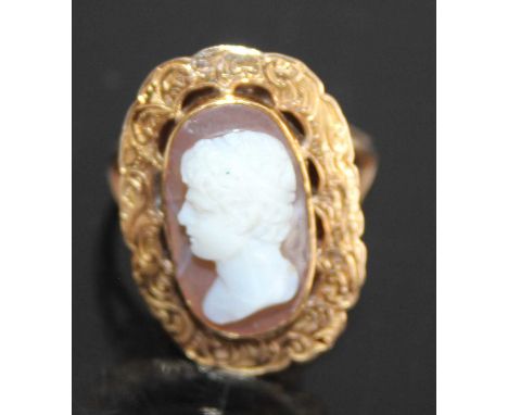 A yellow metal carved shell cameo set ring, depicting profile portrait of a young Roman male and measuring approx 16 x 5 x 10