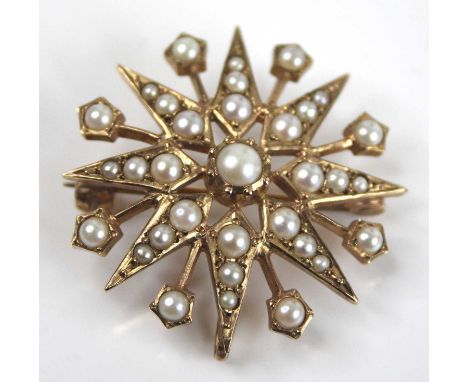 A 9ct yellow gold pearl set 16-ray star brooch, having twenty-one 1.6 to 4.1mm half pearls in grain settings, with roller cat