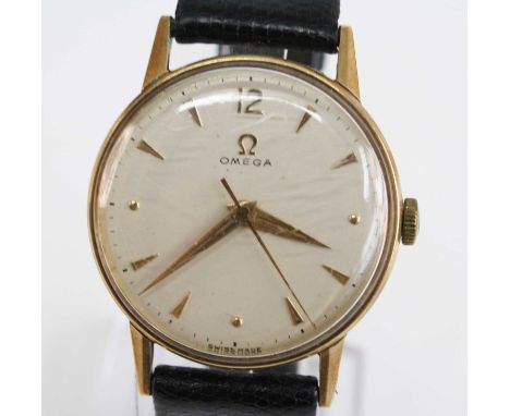 A 14ct yellow gold vintage Omega manual wind wristwatch, having a round cream baton dial and fitted to a black leather strap 