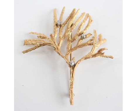 A yellow metal diamond set brooch, in the form of textured branches with three Old European cut diamonds, having roller catch
