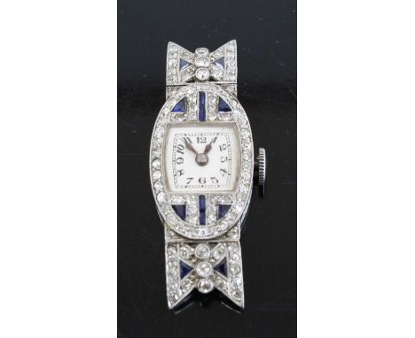 An Art Deco platinum sapphire and diamond set cocktail watch having a signed silvered Arabic dial within a surround of milleg