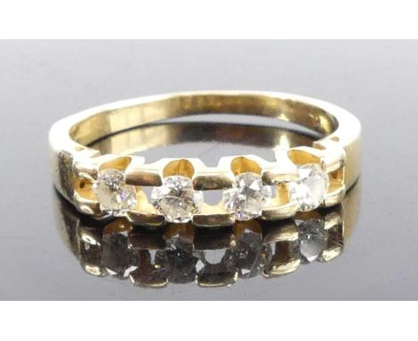 A yellow metal diamond half hoop eternity ring, featuring four round brilliant cut diamonds in tension settings alternating w