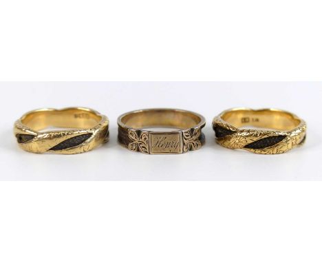 Three yellow metal and woven hair mourning rings, comprising two twisted bands with engraved floral detail alternating with b