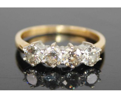 An 18ct yellow and white gold diamond four-stone ring, featuring four round brilliant cut diamonds in claw settings, diamond 