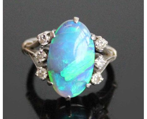 An 18ct white gold, black opal and diamond dress ring, having a centre oval cabochon opal flanked to either side by three rou