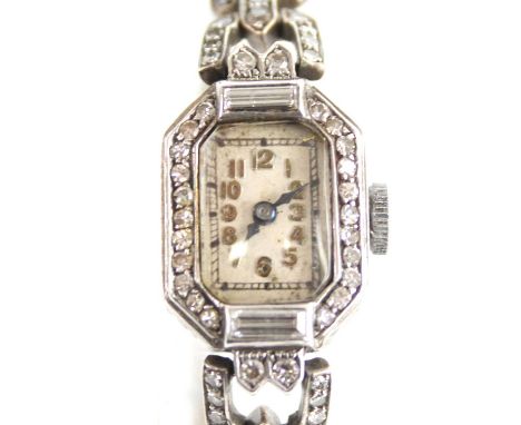 A white metal diamond set Art Deco lady's manual wind cocktail watch, having an octagonal cream Arabic dial and bezel set wit